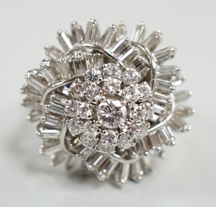 A white metal, baguette and round cut diamond spiral cluster set dress ring, size P, gross weight 14.7 grams.